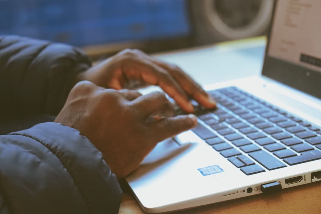 Person typing on a laptop with legal documents spread out