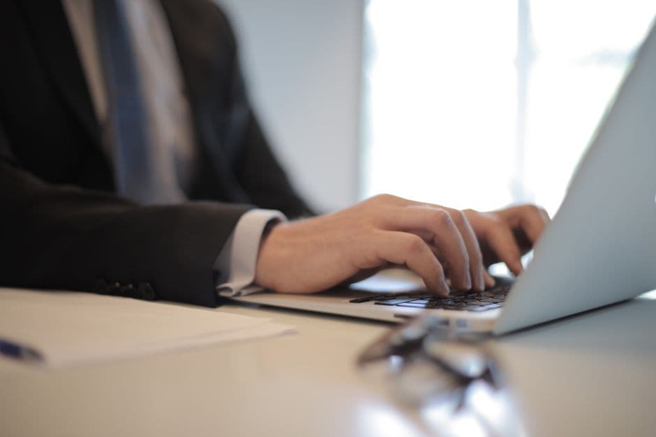 person typing on a laptop preparing legal documents